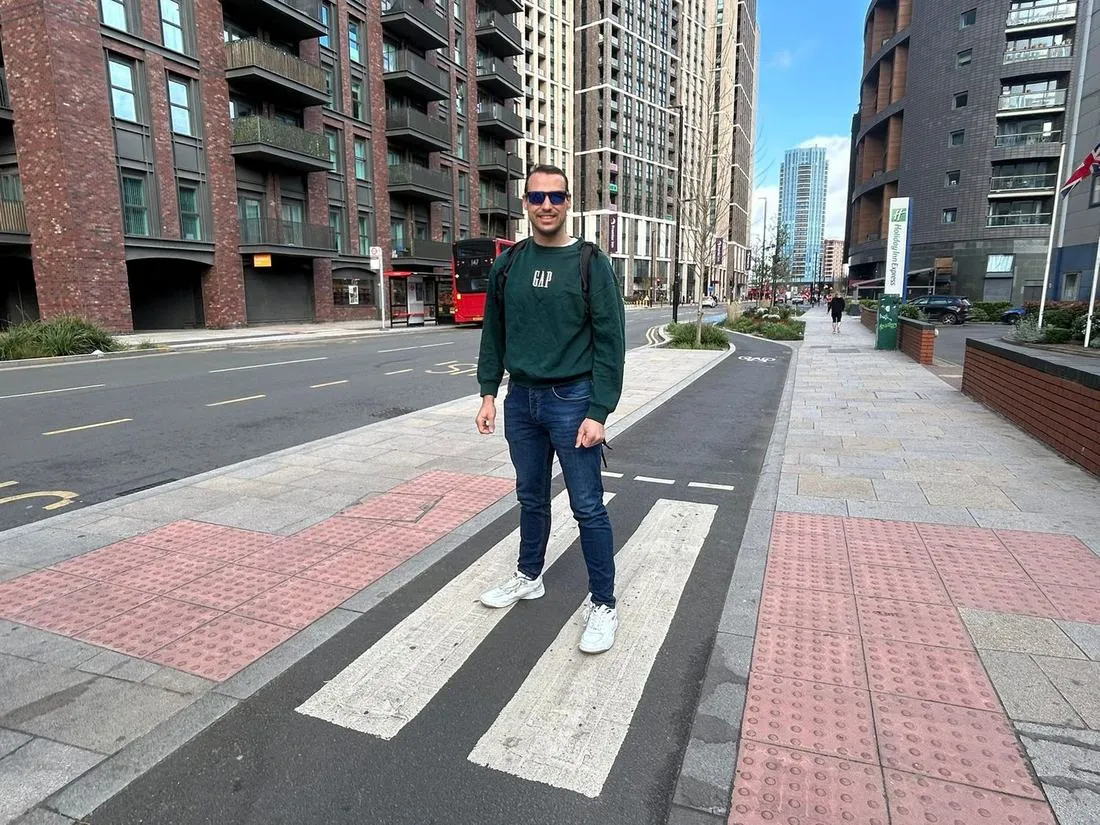 John Morris standing on a new pedestrian crossing alongside a segregated cycle lane on the Royal Docks Corridor