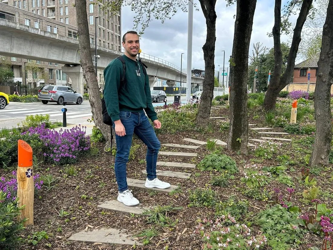 John Morris walking through Silvertown Garden, a planted pocket park with wildflowers alongside the Royal Docks Corridor